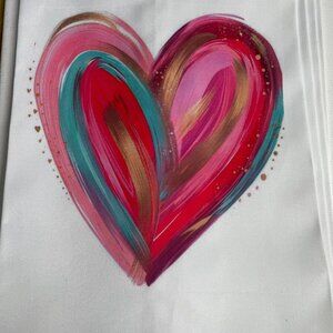 white tea towel featuring an eye-catching multi-color heart design